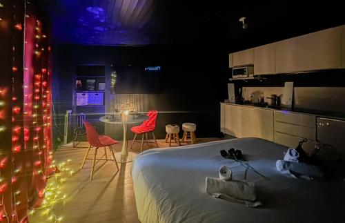 une chambre avec un lit, une table et des chaises dans l'établissement Loveroom Adults Only jacuzzi vieille ville Annecy, à Annecy