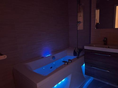 a bathroom with a tub with blue lights in it at Loveroom Adults Only jacuzzi vieille ville Annecy in Annecy