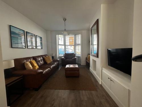a living room with a couch and a tv at House - Sleeps 6 Pet Friendly & Courtyard in Weymouth