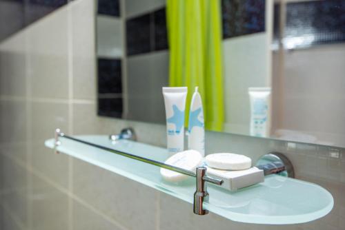 a bathroom counter with a mirror and a sink at Hotel Del Mar Venus in Venus