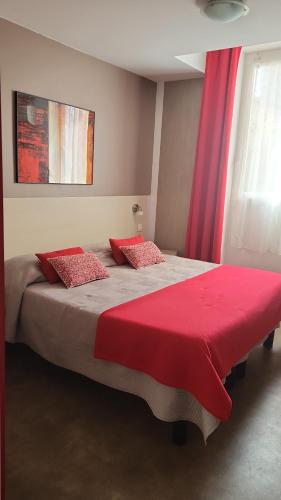 a bedroom with a large bed with a red blanket at Hotel Parisien in Menton