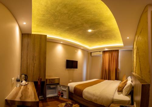 a hotel room with a bed and a yellow ceiling at Divya Boutique Inn in Kathmandu