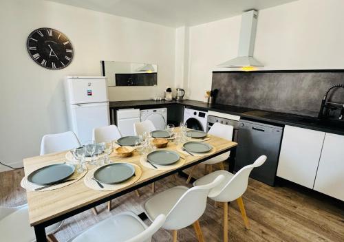 - une cuisine avec une table en bois et des chaises blanches dans l'établissement Maison de ville avec jardin, à Migné-Auxances