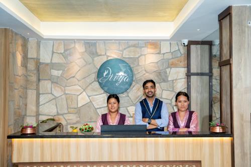 a man and three women standing behind a counter at Divya Boutique Inn in Kathmandu