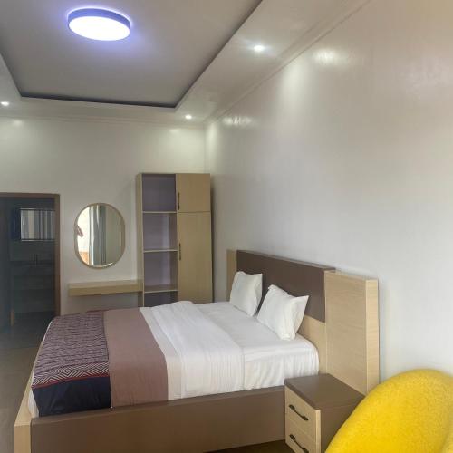 a bedroom with a bed and a mirror and a chair at Ruhondo Beach Resort in Ruhengeri