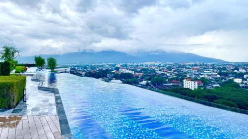 a swimming pool with a view of a city at The Astra Sky River Luxury Condo,the largest pool in Chiang Mai