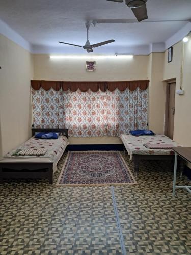 a room with two beds and a table in it at 1 Room for 4 Guests OR 2 BHK for 4 to 10 Guests with AC for Families in Hyderabad