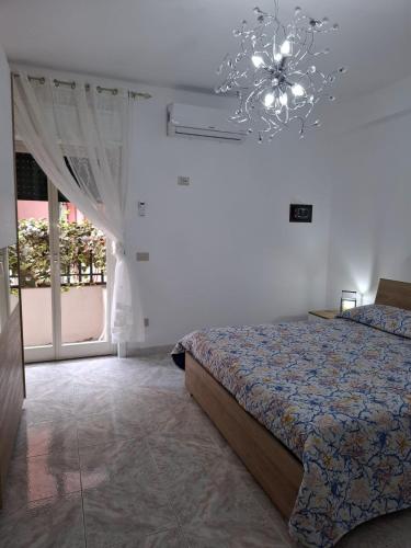a bedroom with a bed and a chandelier at Elisabeth House in Giardini Naxos