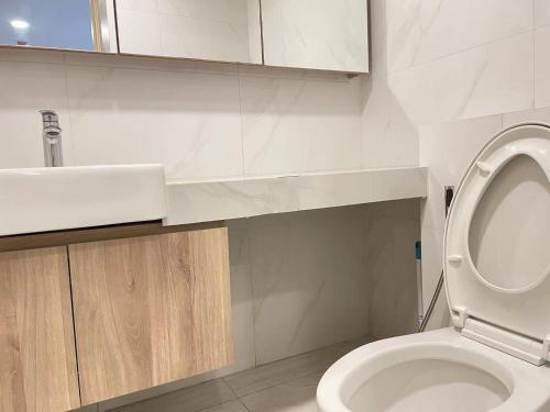 Un baño con un inodoro blanco y un lavabo. en Botique condo in Asoke, en Bangkok