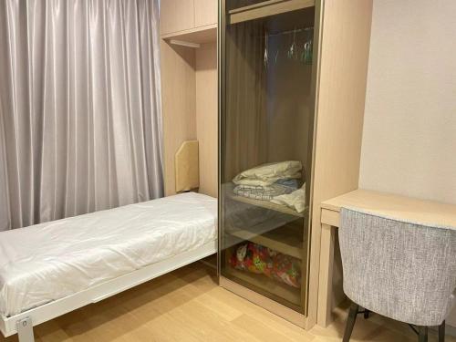 Una habitación con una vitrina con una cama y una silla. en Botique condo in Asoke, en Bangkok