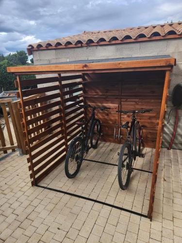 two bikes are parked in a wooden garage at L'étape méditerranéenne logement 4-6 personnes avec parking privé in Sauvian