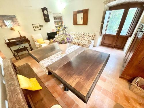 a living room with a wooden table and a couch at Exclusive pool - wondrous views - biological Gardens - pool house - 12 guests in Marzolini