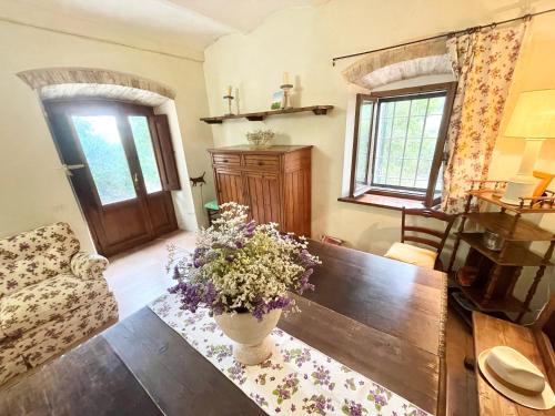 a living room with a table and a vase of flowers at Exclusive pool - wondrous views - biological Gardens - pool house - 12 guests in Marzolini