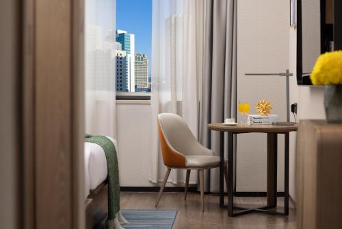a room with a table and a chair and a window at Anya Hotel -Next to Jiefang West Bar Street 2 minutes to the subway station free coffee free laundry free gym, huge windows in Changsha