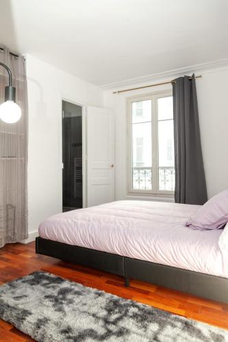 une chambre avec un grand lit et une fenêtre dans l'établissement Charmant appartement - 4 couchages à proximité d'Opéra et des métros, à Paris
