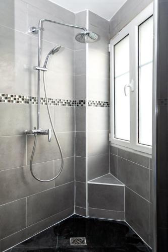 une douche avec une porte vitrée dans une salle de bain dans l'établissement Charmant appartement - 4 couchages à proximité d'Opéra et des métros, à Paris