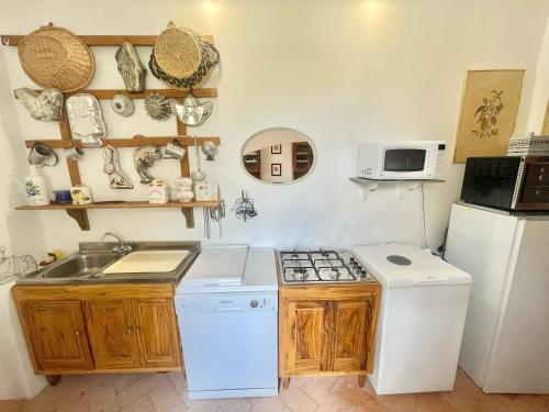 a kitchen with a sink and a stove and a refrigerator at Exclusive pool - wondrous views - biological Gardens - pool house - 12 guests in Marzolini
