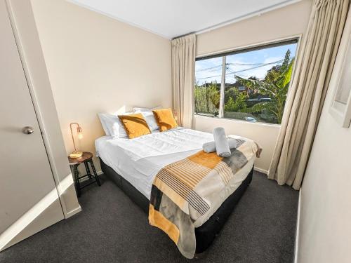 a bedroom with a bed and a large window at Onehunga Oasis l 2bed Private Home l Cornwall Park in Auckland