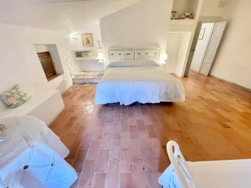 a bedroom with a bed and a wooden floor at Exclusive pool - wondrous views - biological Gardens - pool house - 12 guests in Marzolini