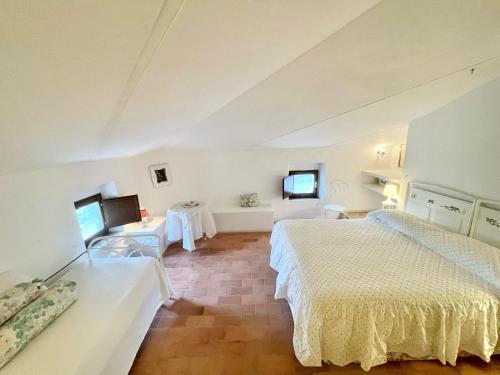a hotel room with two beds and a television at Exclusive pool - wondrous views - biological Gardens - pool house - 12 guests in Marzolini