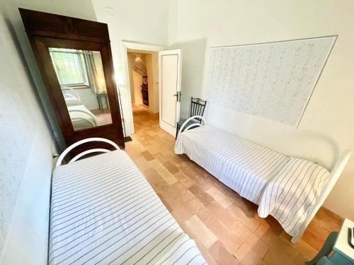 a bedroom with two beds and a mirror at Exclusive pool - wondrous views - biological Gardens - pool house - 12 guests in Marzolini