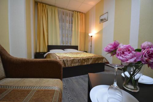 een hotelkamer met een bed en een tafel met bloemen bij Hotel Karat in Moskou