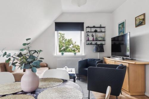 a living room with a table and a tv at Ama Hyg Atelier Copenhagen-LOVELY TOP FLOOR Apart -NEAR AIRPORT-METRO AND THE BEACH in Copenhagen