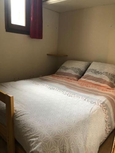 ein Schlafzimmer mit einem großen Bett mit Fenster in der Unterkunft T2 Rez-de-chaussée terrasse et table extérieure in Enchastrayes