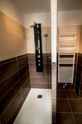 La salle de bains est pourvue d'une douche et de carrelage brun. dans l'établissement La Villa Farniente, à Bandol