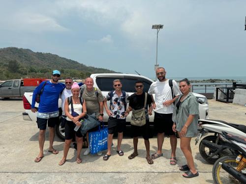 a group of people standing in front of a car at Angthong Beach Resort in Koh Phaluai