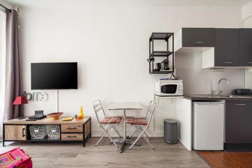une cuisine avec deux chaises, une table et un four micro-ondes dans l'établissement Nid Malouin Saint-Malo intramuros plage à 200m, à Saint-Malo