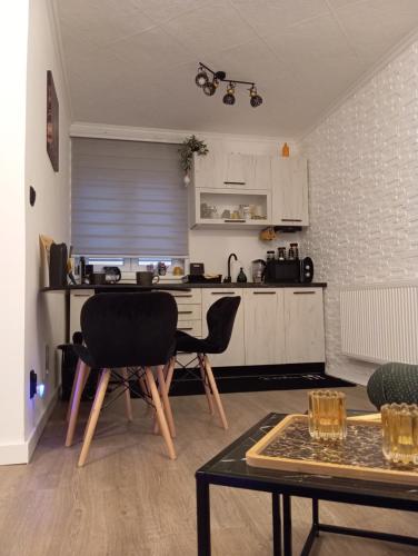 a kitchen with a table and chairs in a room at Black Diamond Lux - deluxe riverside apartment in Senta