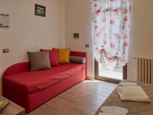 a red couch in a living room with a window at BnB Anna e Leo - Casa di Anna in Pietra Montecorvino