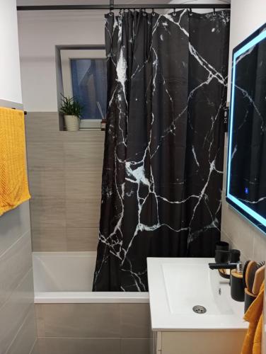 a bathroom with a black marble shower curtain at Black Diamond Lux - deluxe riverside apartment in Senta
