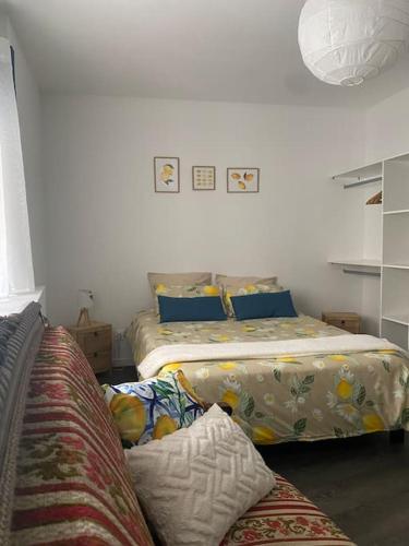 une chambre avec deux lits et un canapé dans l'établissement Appartement spacieux et confortable au centre de Chambéry L'appart de L'atelier du citron et sa déco citronnée, à Chambéry