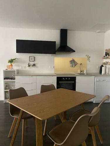 une cuisine avec une table et des chaises en bois dans l'établissement Appartement spacieux et confortable au centre de Chambéry L'appart de L'atelier du citron et sa déco citronnée, à Chambéry