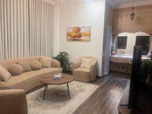 a living room with a couch and a table and a sink at Ban Luxury Apartments in Al Khobar