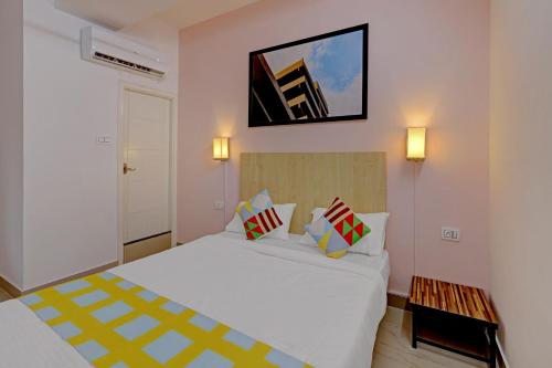 a bedroom with a white bed and a picture on the wall at Hotel O Compact Studio Kr Puram Near Phoenix Marketcity in Bengaluru