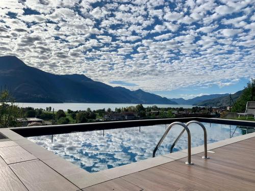 a swimming pool with a view of a lake and mountains at BELLA VITA Residence in Gravedona