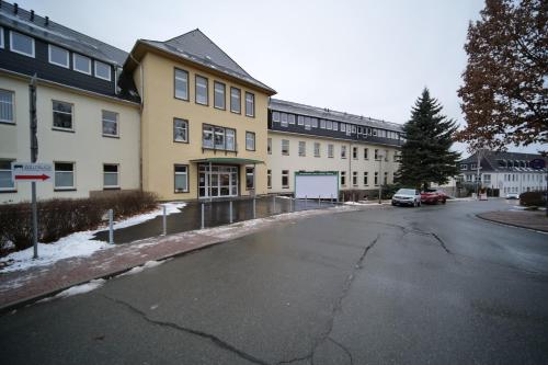 an empty street in front of a large building at Wunderschöne Ferienwohnung mit Balkon in Aue in Aue