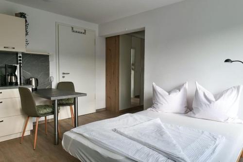 a bedroom with a bed and a desk and a table at Wunderschöne Ferienwohnung mit Balkon in Aue in Aue