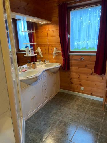 un bagno con lavandino e specchio di Chalet Aster 3 étoiles a Arrentès-de-Corcieux
