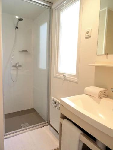 une salle de bain blanche avec une douche et un lavabo dans l'établissement La Bohême, à 10min en voiture de Disneyland, à Chalifert