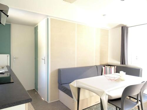 - un salon avec une table blanche et un canapé bleu dans l'établissement La Bohême, à 10min en voiture de Disneyland, à Chalifert