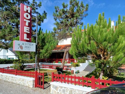 a sign in front of a hotel with a red fence at Hotel Verde Pinho Bed&Breakfast in São Pedro de Moel
