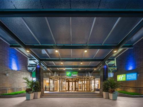 an entrance to a building with plants in front of it at Holiday Inn Express Shangdi Beijing by IHG l Next to The Old Summer Palace & Qinghe Railway Station & Subway l Taxi 15 Minutes to Summer Palace & Peking University & Tsinghua University l 20 Minutes to Badaling Great Wall by Railway in Beijing