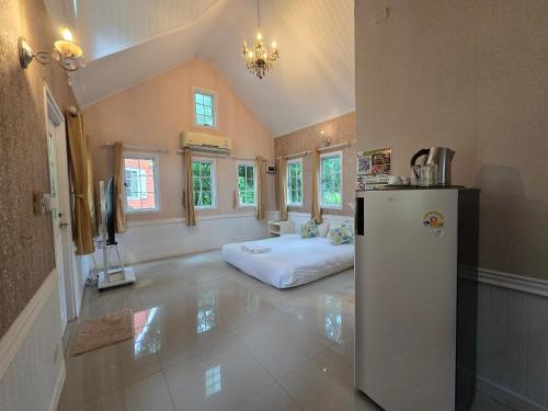a room with a refrigerator and a bed in it at Puprai Tarnnarm Resort in Thong Pha Phum