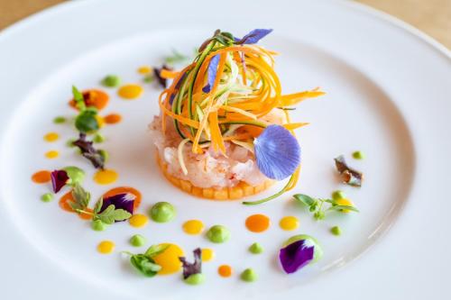 a white plate with a dish with food on it at Cervo Hotel,Costa Smeralda Resort in Porto Cervo