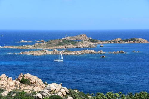 a sail boat in the water near an island at Cervo Hotel,Costa Smeralda Resort in Porto Cervo