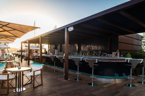 a bar on a deck with tables and chairs at Cervo Hotel,Costa Smeralda Resort in Porto Cervo